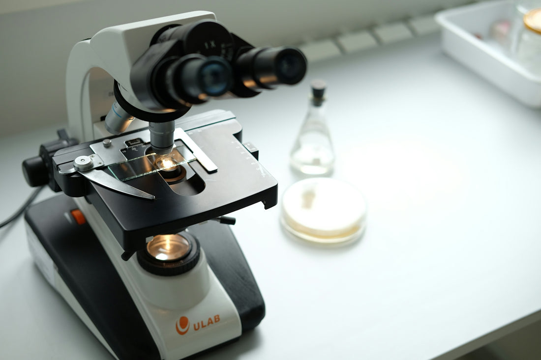 A microscope sitting on top of a table next to a bottle