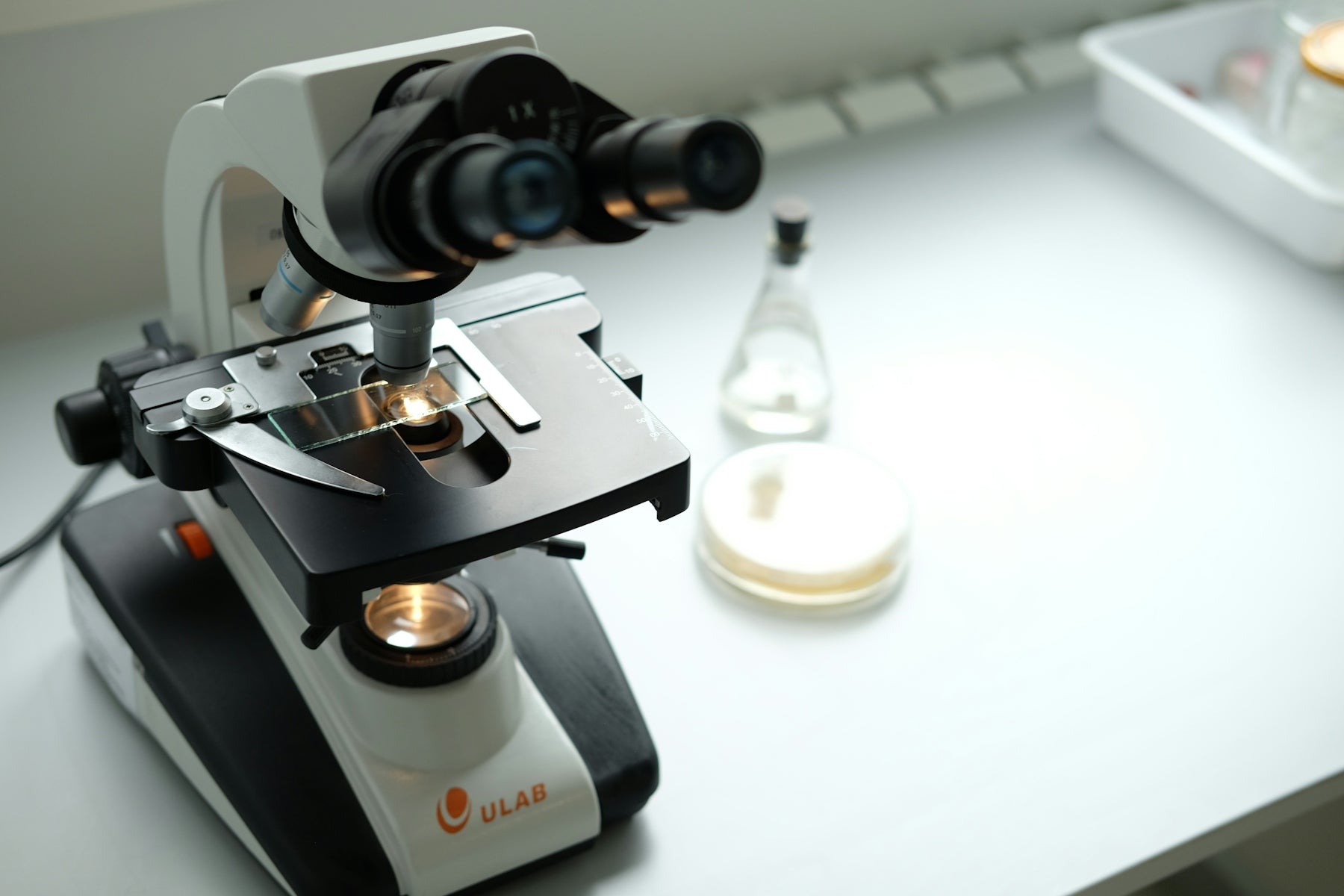 A microscope sitting on top of a table next to a bottle